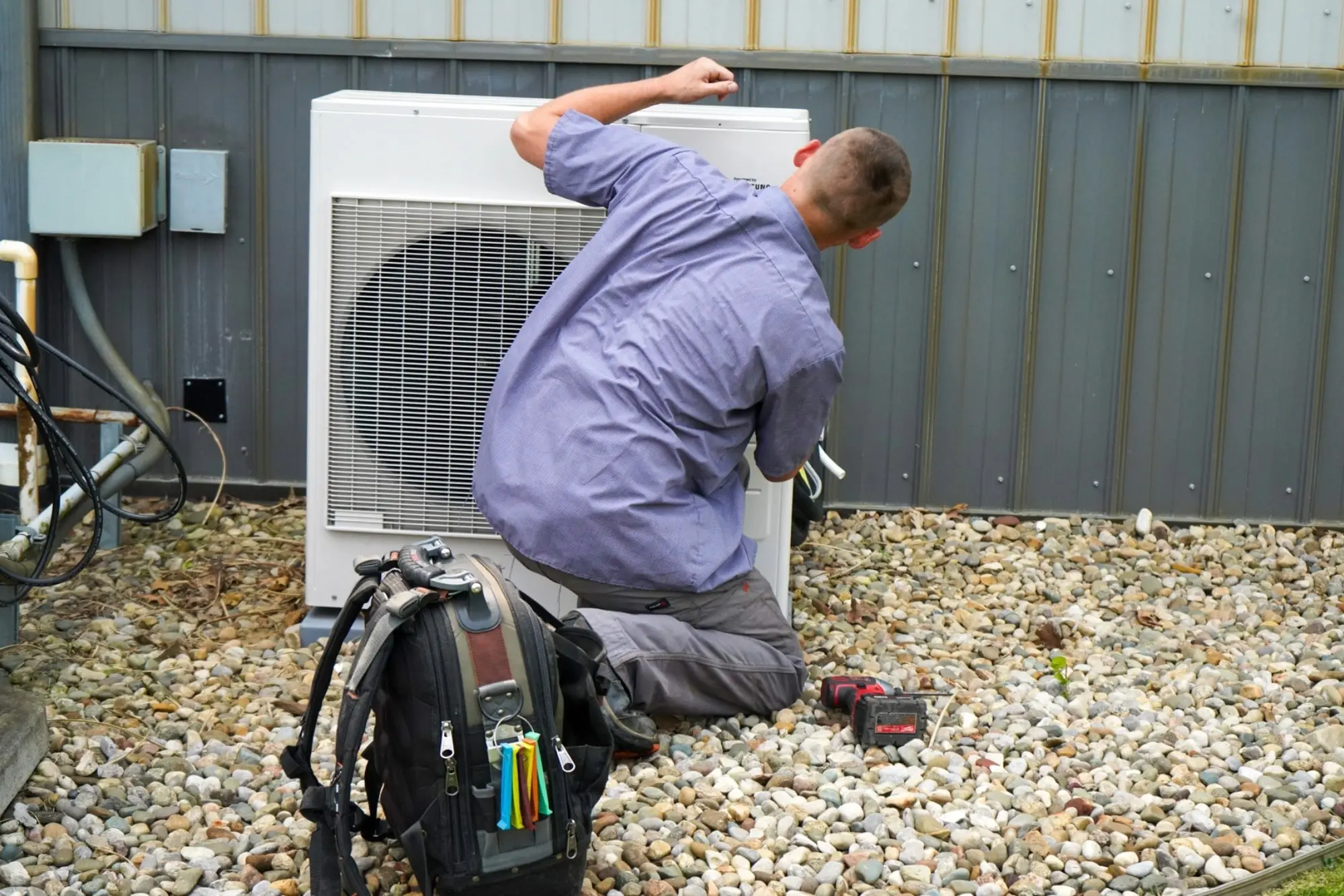 HVAC technician performing maintenance on an outdoor heat pump unit | Eric Dale Heating & Air Conditioning